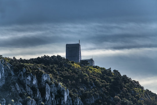 Santuario nazionale di Monte Grisa a Trieste, al tramonto, con un cielo carico di nubi e tempesta