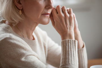 Close up view of thoughtful mature woman worried concerned about problems or disease, middle aged...