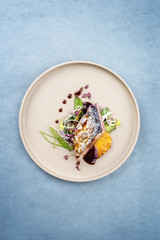 Modern style Japanese bonito tuna fish filet with vegetable and pineapple glazed in teriyaki sauce as closeup on a plate
