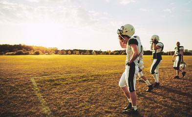 Young American football players walking off a field after practi © Flamingo Images