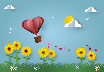 Love and valentine day. Heart air balloon up above sunflower field