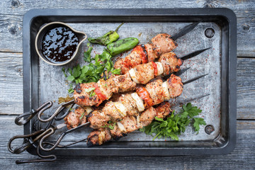 Traditioneller griechischer Souvlaki Grillspieß mit Zwiebel und Paprika als closeup auf einem Metall Blech