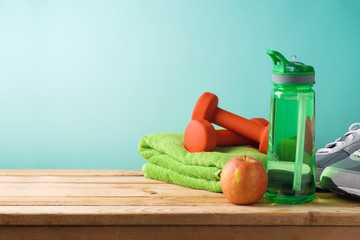 Fitness background with bottle of water, dumbbells and towel