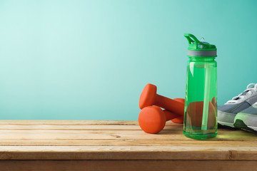 Fitness background with bottle of water, dumbbells and shoes