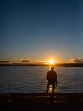 Man fishing from a Quay in the Sunset