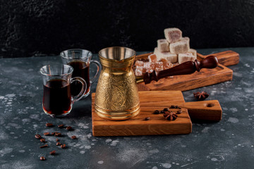 Coffee turk and cup of coffee on wooden board. Roasted beans. Metal turk and coffee beans on a wooden background turkish coffee.