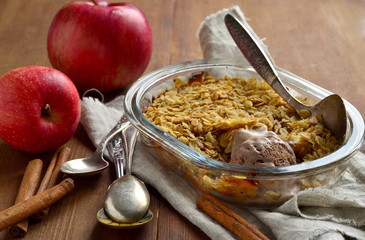 Oatmeal apple crumble with ice cream in a baking dish