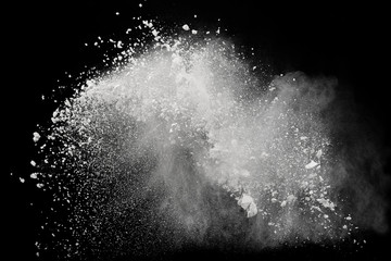 White powder or flour explosion isolated on black background; freeze stop motion object design
