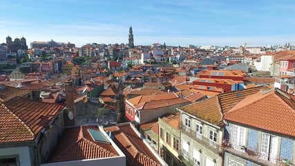 Fototapeta na wymiar Aerial motion video on view of orange rooftops and historical buildings of the old city and Clerigos church tower of Porto, Portugal