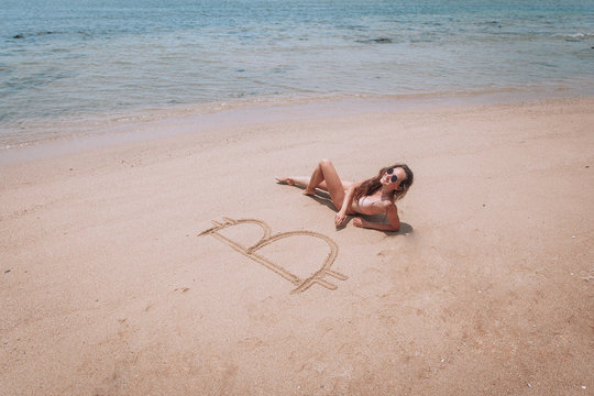 Image of icon bitcoin on golden sand, near sit happy bitcoin girl . Concept freelance, stock exchange