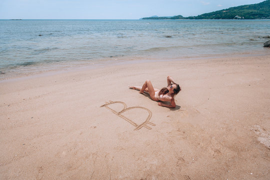 Image of icon bitcoin on golden sand, near sit happy bitcoin girl . Concept freelance, stock exchange