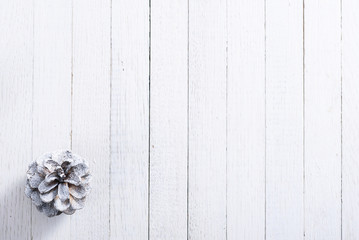 snow painted pine cone on rustic white wood table, Christmas decoration background