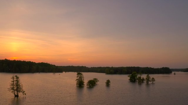 Slow flying aerial footage through the stumpy lake wetlands in the Virginia Beach area during sunset with birds flying throughout the scene
