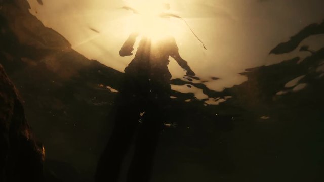 Buceo y nataci&oacute;n en el oc&eacute;ano al atardecer. Silueta de hombre abstracta con reflejos del agua.Joven divirti&eacute;ndose buceando en el mar. Aventuras y entretenimiento en la playa 