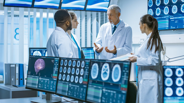 Meeting of the Team of Medical Scientists in the Brain Research Laboratory. Neurologists / Neuroscientists Having Heated Discussion Surrounded by Monitors Showing CT, MRI Scans.