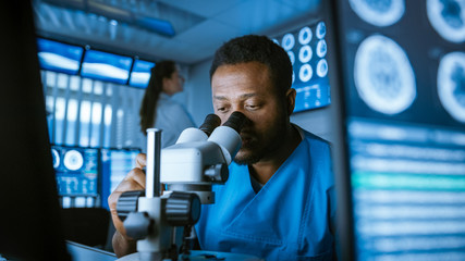 Medical Research Scientist Looking under the Microscope in the Laboratory. Neurologist Solving...