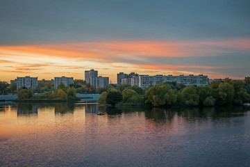 Fototapeta na wymiar Beautiful cloudy sky at sunset over the river in evening city