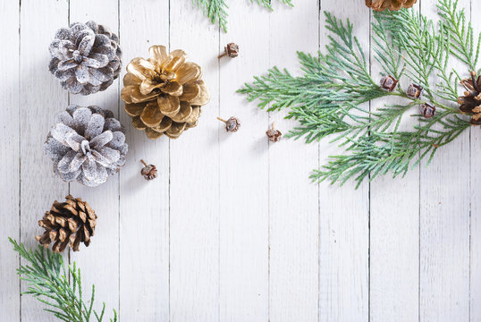 Christmas decoration background: pine and cypress cones with twigs on white wood table