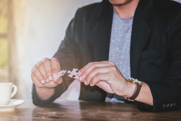 Business man hands connecting jigsaw puzzle. Business solutions, success and strategy concept. Close up photo with selective focus.