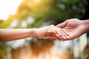 The lady hand touch on hand of husband,love hand sign,for trust and care,warm light tone,blurry...