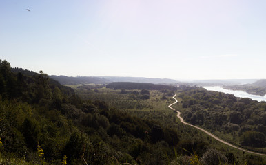 Epic panoramic view from up hill with river and narrow road,