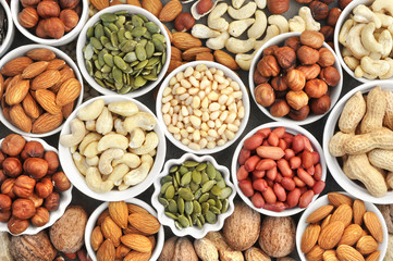 Colorful mix of nut and seed varieties: peanut, cashew, hazelnut, almond, pine nuts, walnut,...