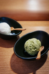 Green tea Matcha ice cream scoop in black bowl