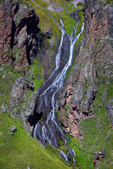 Waterfall on the rocky slopes of the Caucasus Mountains in Russia.