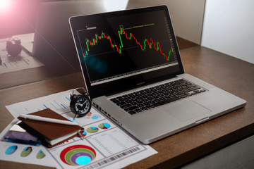 A Computer Tablet and ultra-slim smartphone with candle stick chart on the screen a business and finance conceptual