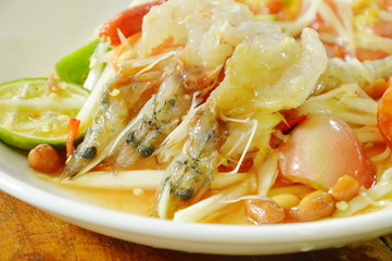 Som tum Thai spicy green papaya topping raw prawn salad on plate