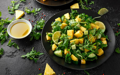 Pineapple Cucumber salad with wild green rocket, lime and olive oil. Healthy juicy food
