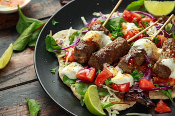 Lamb mint kebabs with flatbread, mix of vegetables, lime and greek yoghurt chilli sauce