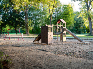 Image of wooden playgound on sandy ground