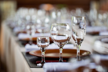 Glasses, forks, knives, plates on a table in restaurant served for dinner