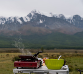 The food is prepared against the backdrop of the mountains.