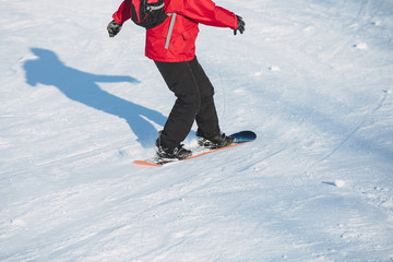 Unrecognizable man snowboarding