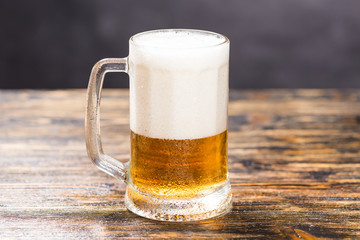Glass of beer on wooden table. A mug of beer