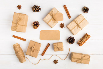 Fototapeta na wymiar Kraft paper gifts and spices on a white table. The original decor for Christmas. Beautiful layout, top view, flat lay.