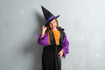 Happy little girl dressed as a witch for halloween holidays