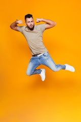 Full length portrait of a smiling young casual man jumping