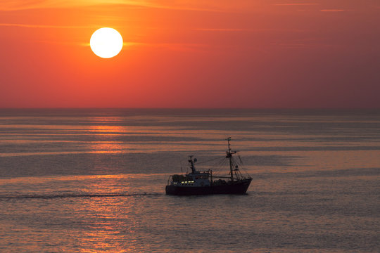 Fishing trawler on the North Sea at sunset