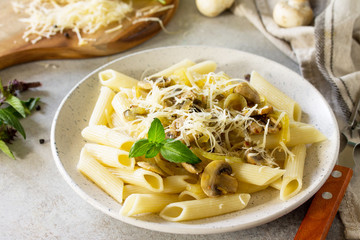 Pasta Penne with mushrooms and cheese on stone table. Vegetarian vegetable mushrooms pasta.