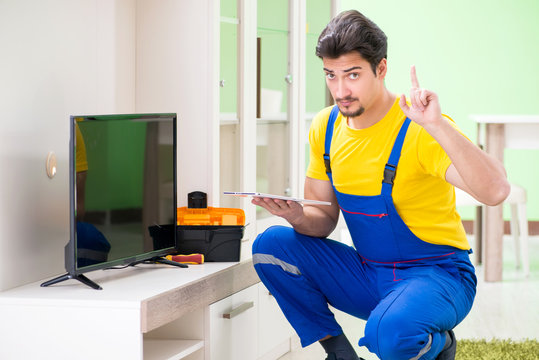 Male professional serviceman repairing tv at home