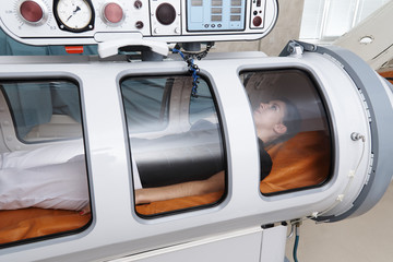 A hyperbaric chamber with a girl lying inside.
