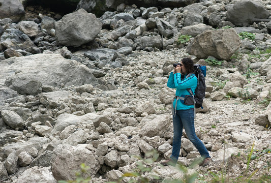 Woman tourist takes pictures on a mountain landscape.