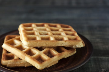 Viennese, Belgian waffles with honey on a white plate.