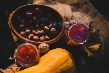 Fotobehang Autumn still life with quince jam, goud, pumpkins, hazelnuts, nuts and leaves on wooden background. Copy space. © MarkoVS87