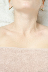 Mesotherapy in the neck and chest-neckline. Traces of hyaluronic acid injections. Light background. View from above.