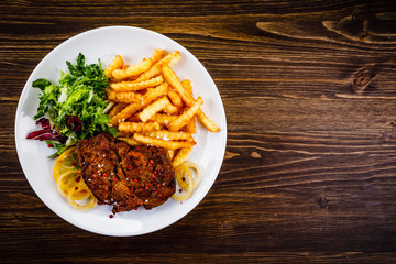 Grilled beefsteak with french fries and vegetable salad