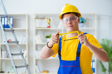 Young contractor doing repair works at office 